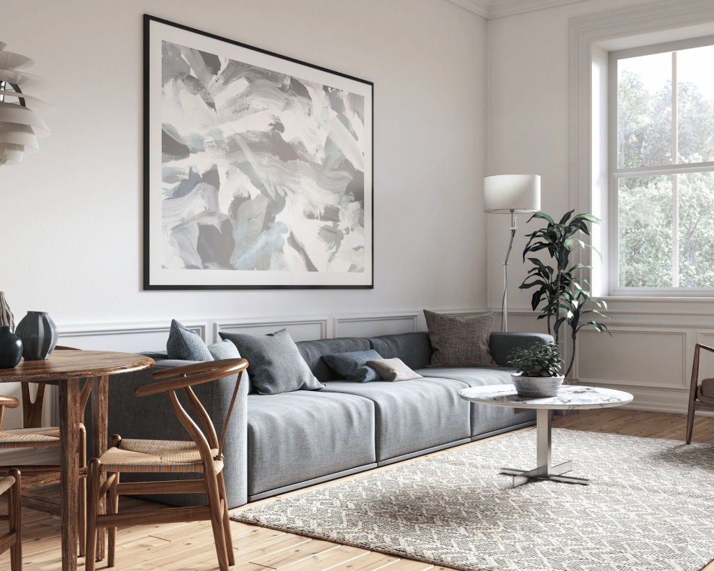 room with light grey walls and a dark grey sofa with blue accent pillows